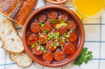 Chorizo a la sidra servido caliente en un plato de terracota.