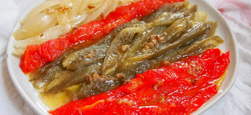 Escalivada Catalana: plato tradicional de verduras asadas de la gastronomía catalana, elaborado con berenjenas, pimientos rojos, cebollas y tomates, acompañado de aceite de oliva.