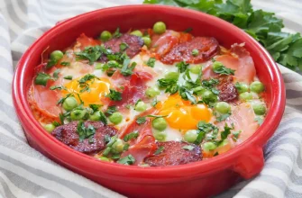 Huevos a la Flamenca, plato tradicional español con huevos y chorizo, servido en un plato de terracota.