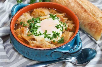 Sopa de ajo española servida en un cuenco con pan, ajo, huevo poché y perejil fresco.