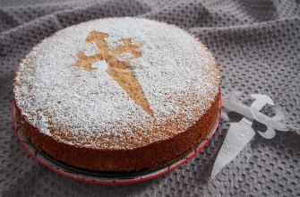 Tarta de Santiago, receta fácil y sin gluten de pastel de almendras decorado con la Cruz de Santiago en azúcar en polvo.