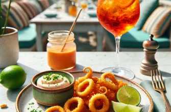 Lulas fritas crocantes acompanhadas de aïoli de lima e Aperol Spritz em uma mesa de verão.